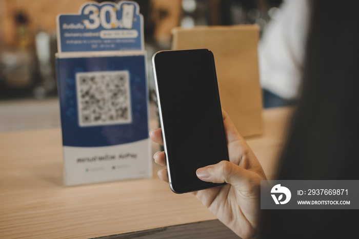 hand customer using digital mobile phone scan QR code paying for buying coffee in modern cafe coffee