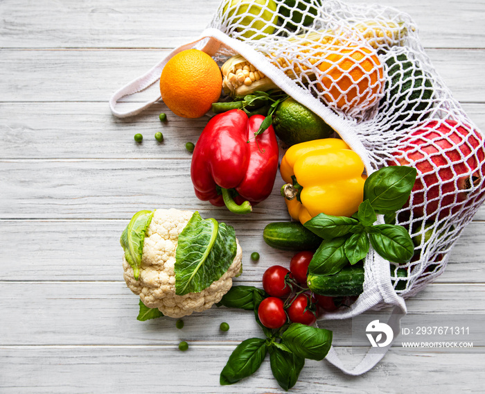 新鲜蔬菜和水果装在白色木质背景的环保绳袋上。健康的生活方式。Top v