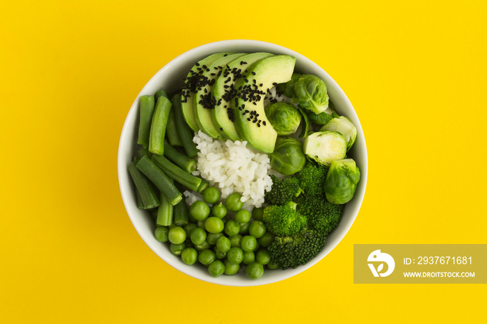 素食主义者戳碗，黄色中央的白色碗里有白米饭和绿色蔬菜