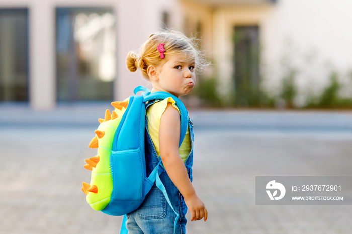 Cute little adorable toddler girl on her first day going to playschool. Healthy upset sad baby walki