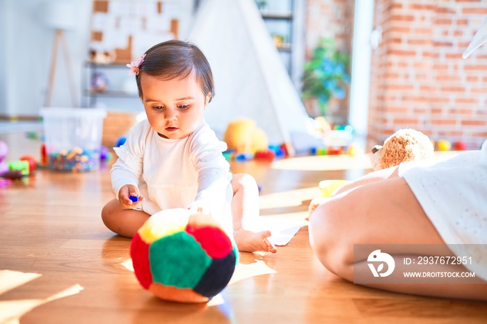 美丽的婴儿在幼儿园围着五颜六色的玩具开心