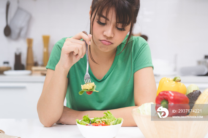 Bored woman eating salad disorder during diet.