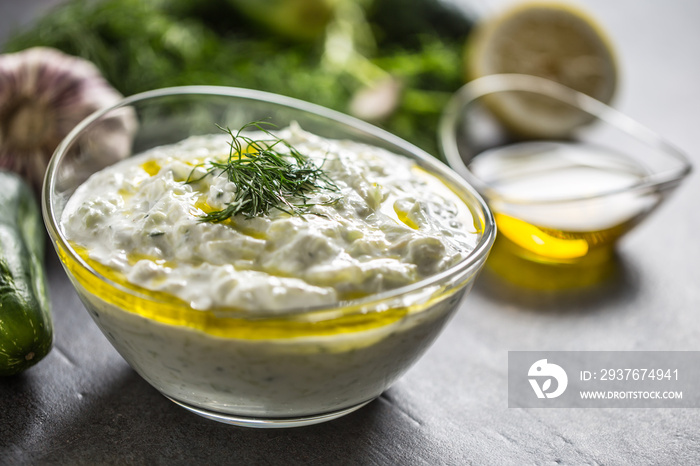 Tzatziki sause in a glass bowl dill cucumber olive oil lemon and garlic