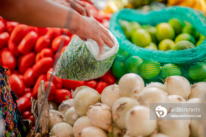 Manos de Mujer vendiendo vegetales en un mercado local.