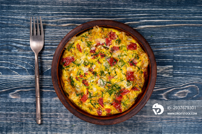 Ceramic bowl with vegetable frittata, simple vegetarian food. Frittata with tomato, pepper, onion an