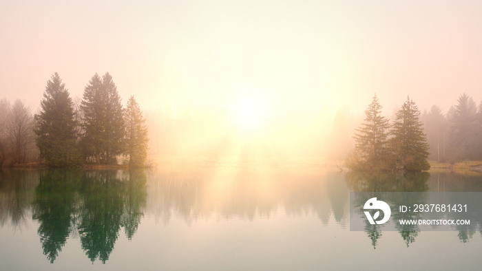 Sunrise at a lake on a foggy morning