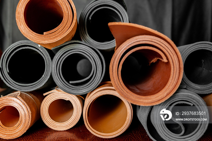 Full frame of brown and black textile genuine leather rolls.