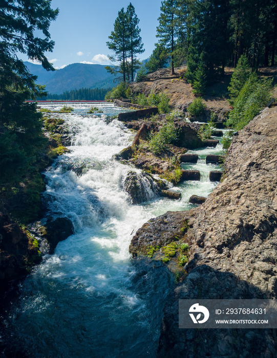 Cascading Clear Lake Falls with Fish Ladder surrounded by rocky cliffs with clouds and a blue sky in