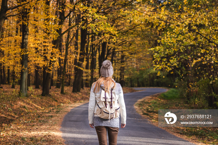 Hiking woman on her journey in autumn forest