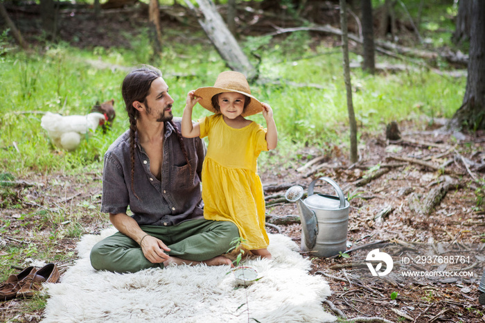 Portrait of girl with father wearing hat in forest