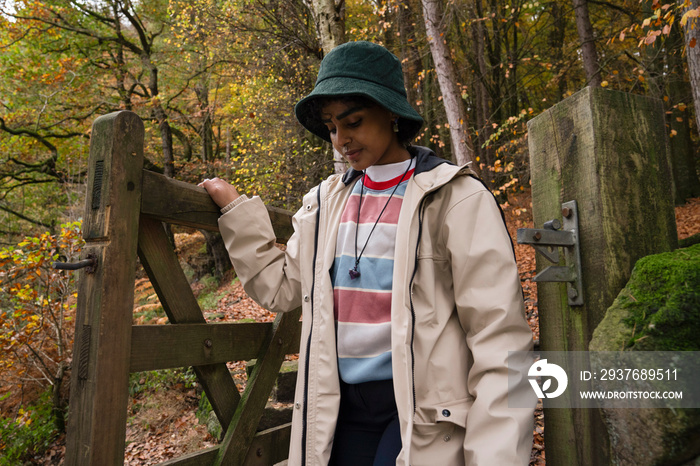 Female hiker walking through gate in forest