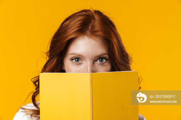 Image of ginger beautiful girl looking out for exercise book