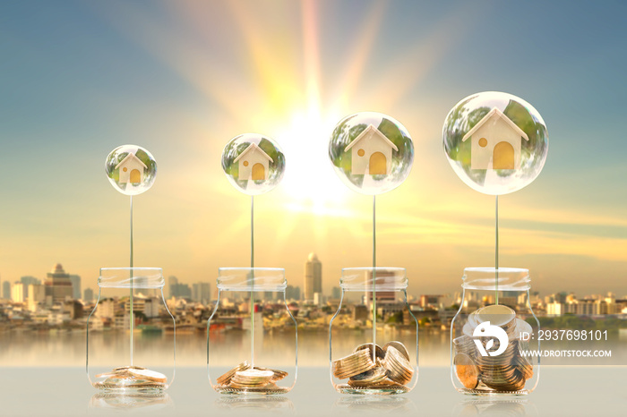 瓶子里的硬币和照片上水晶泡泡里的家模糊了阳光背景下的城市景观，商业