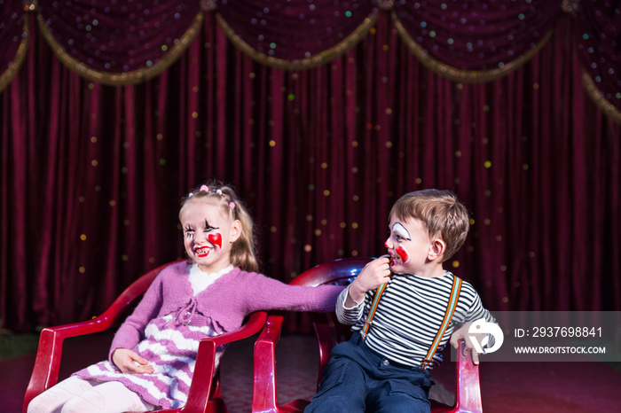 Young Clowns Sitting and Laughing on Stage