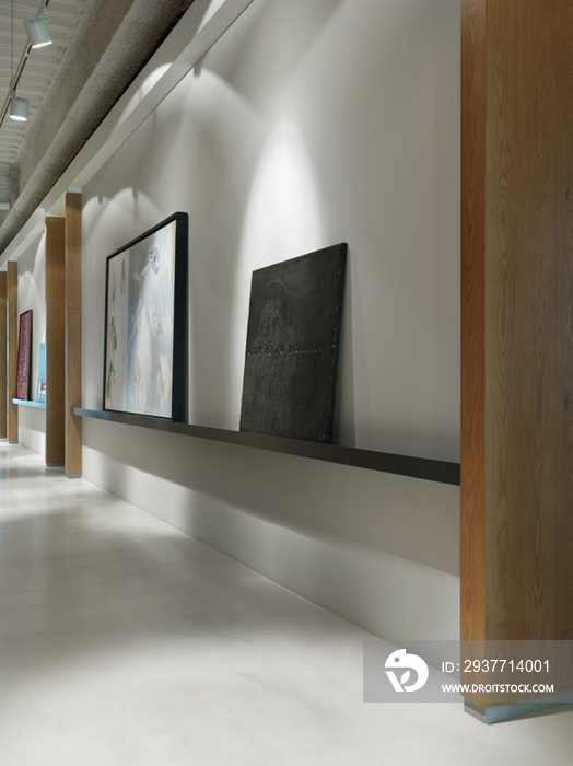 Picture frames on shelf at empty hallway in office