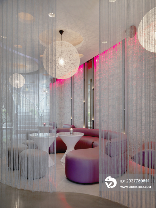 Lounge area through string curtains in modern nightclub
