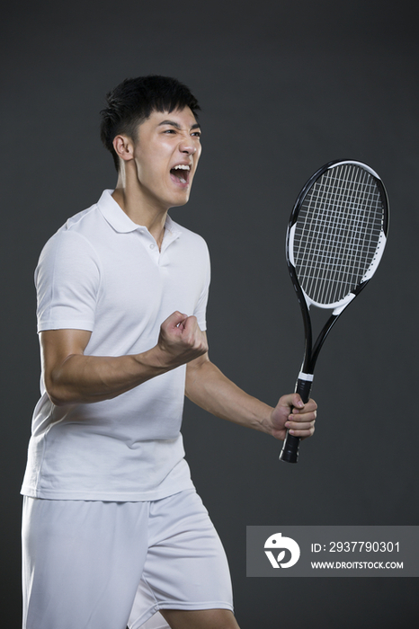年轻男子拿着网球拍欢呼