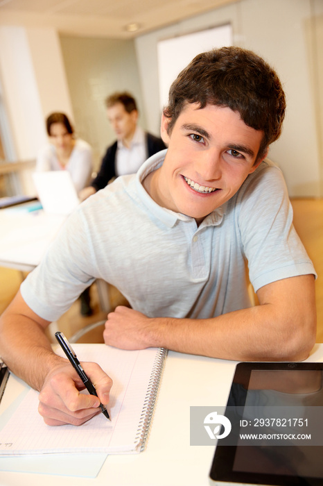 学生男孩的肖像在笔记本上写字