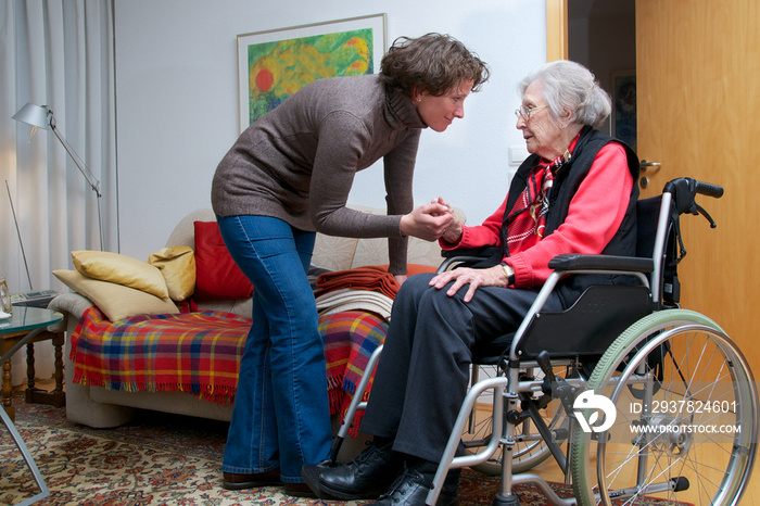 Seniorin im Rollstuhl mit Betreuerin