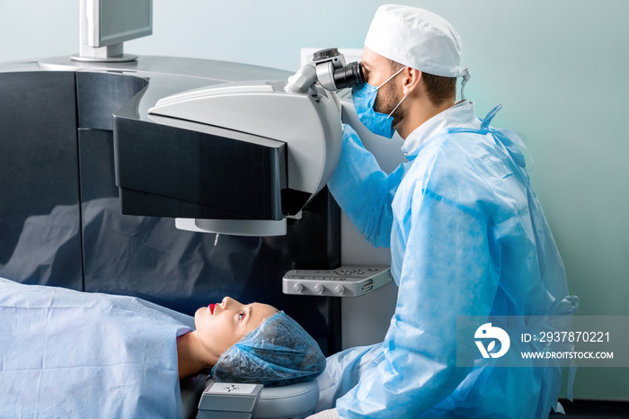 眼科医生在手术室用激光视力矫正机给妇女做手术