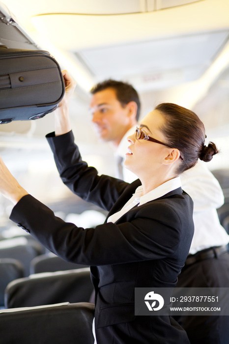 友好的空乘人员帮助乘客拿行李
