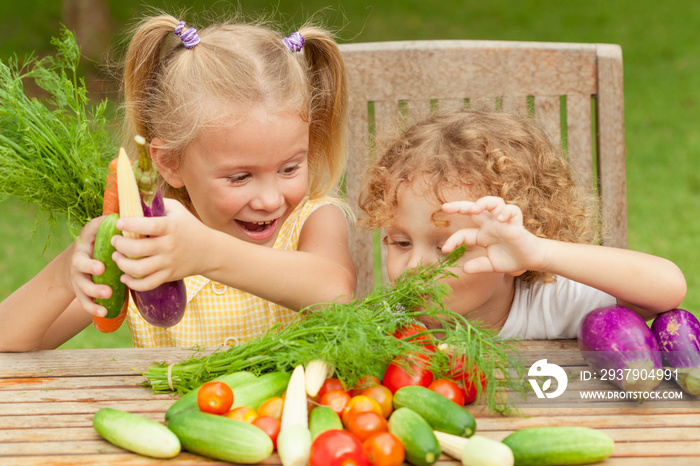 Two happy little kids with vegetables . Concept of healthy food.