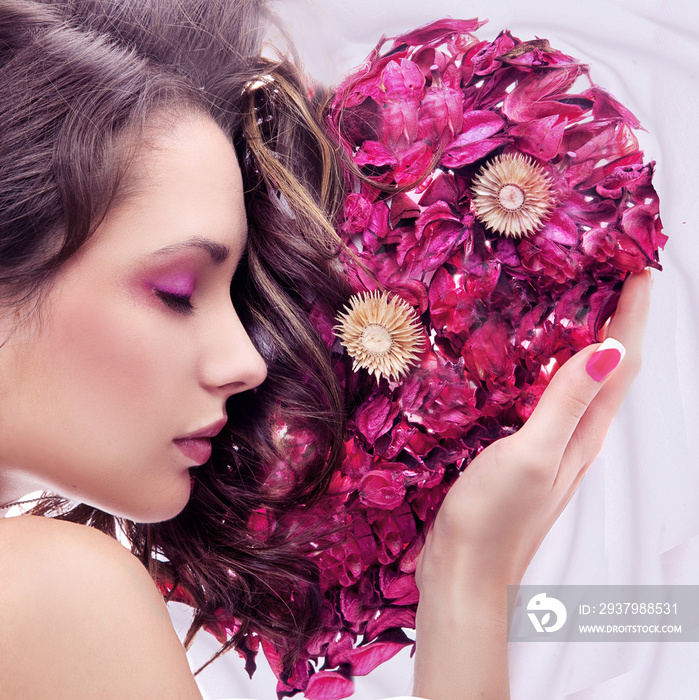 Portrait of a young beauty with rose heart