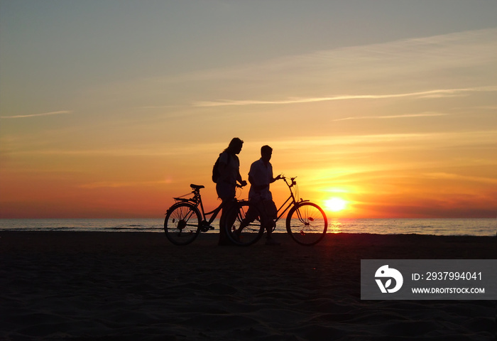 两个骑自行车的人在海滩上