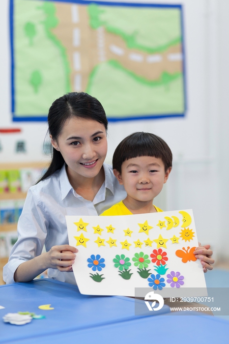 幼儿园女老师和儿童展示手工儿童画