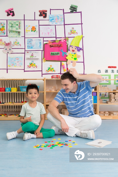 幼儿园外教男老师和儿童一起玩字母游戏