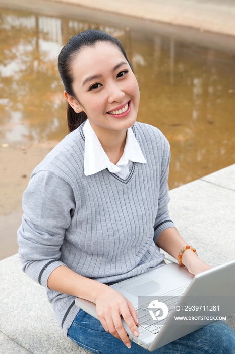 年轻大学生在校园里使用笔记本电脑