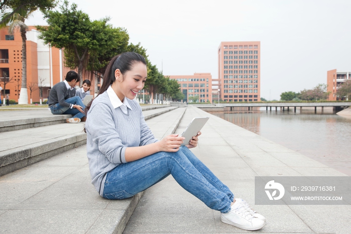 年轻大学生在校园里使用平板电脑