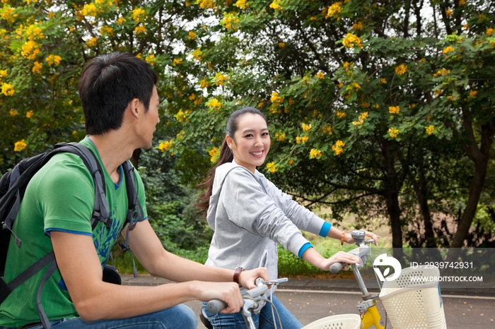 年轻大学生在校园里骑车