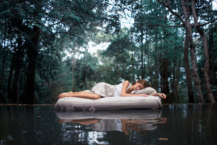 一个隐蔽的地方。森林深处沉睡的女人躺在气垫床上